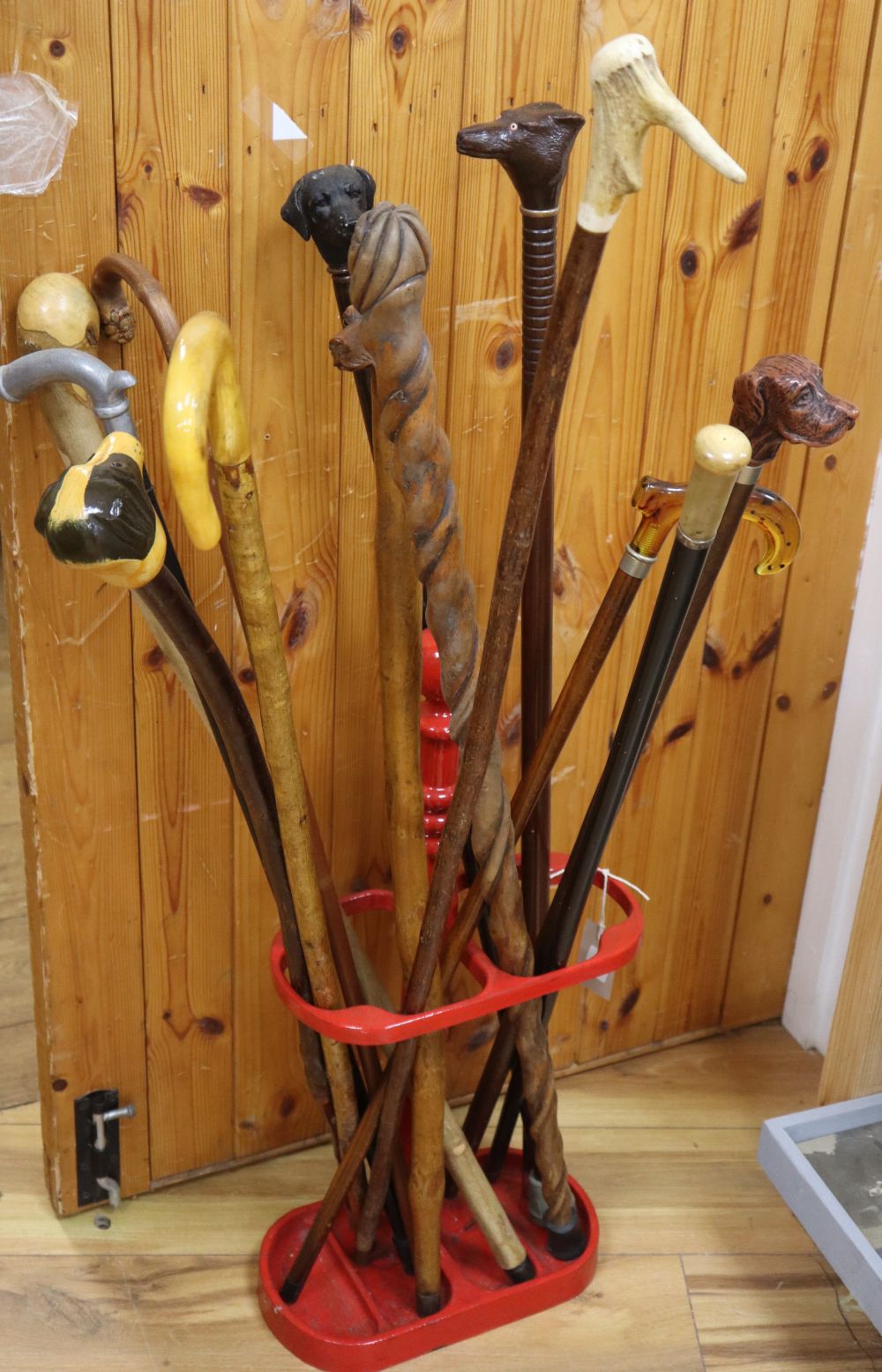 A collection of assorted walking sticks and a stick stand